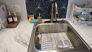 Uma cozinha com pia, adega e um espaço para café.