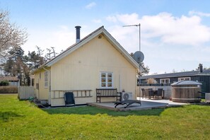 Yhden kerroksen talo, jossa on kalteva katto, savupiippu ja satelliittiantenni.