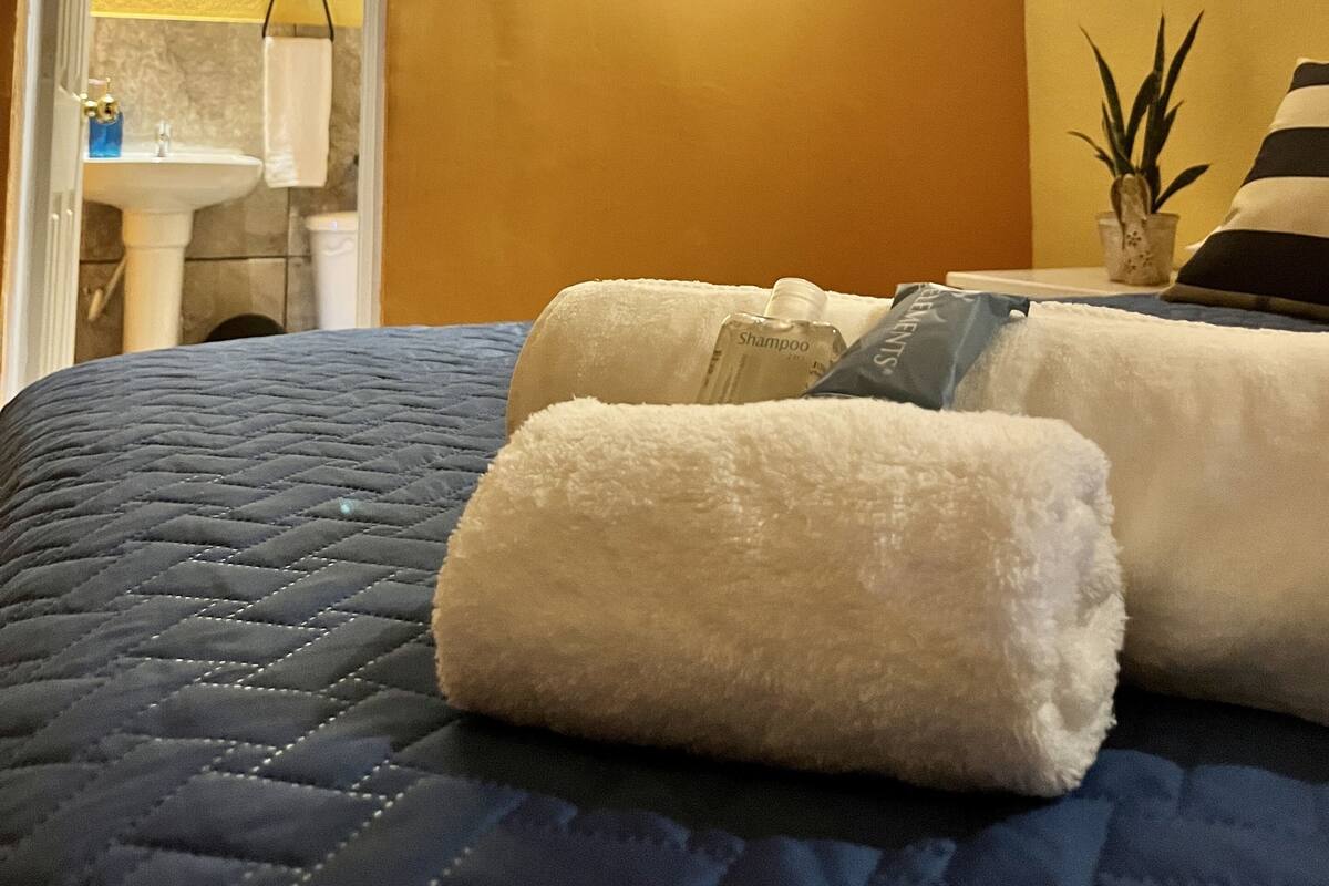 Ein Hotelzimmer mit Bett, einem Bild, einem Badezimmer und einer Klimaanlage.