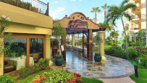Une cour abritant un restaurant appelé « La Fonda Casona », avec une terrasse, des palmiers et un chemin bordé de carreaux.