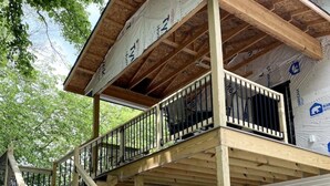 A wooden deck with a railing, supported by wooden beams and covered with insulation material. - Entire Top Floor Only: Okoboji Oasis/ Private Entrance (Arnolds Park)