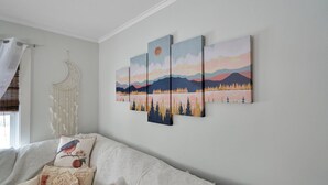 A bedroom with a white bed, a dreamcatcher, and a wall with a landscape painting. - Gorgeous home walking distance to the beach (Rochester)