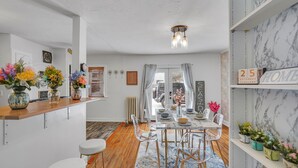 A modern kitchen with a wooden countertop, a dining area with a marble table, and a view of the outside. - Gorgeous home walking distance to the beach (Rochester)
