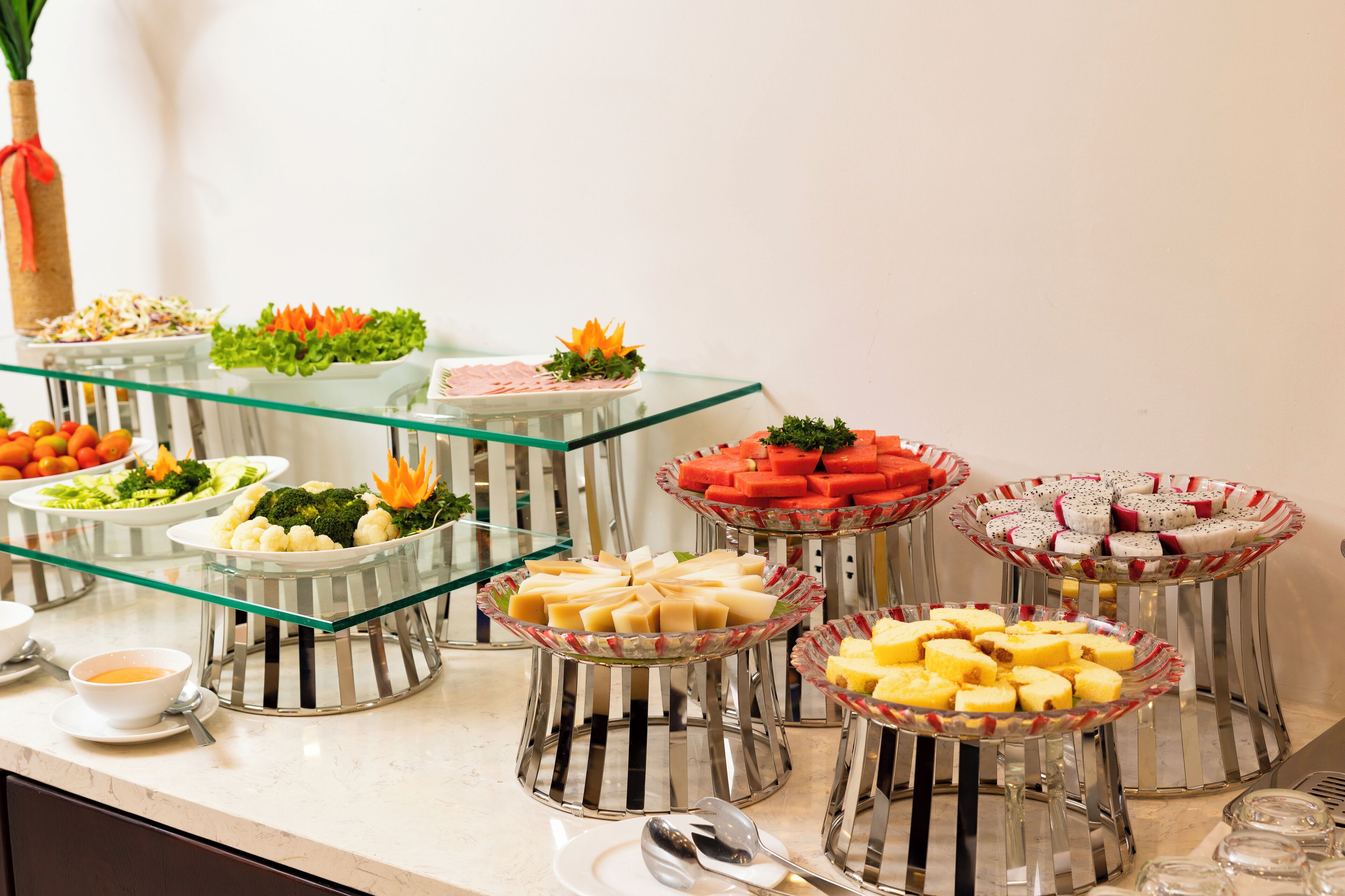 A buffet with various food items on glass stands.