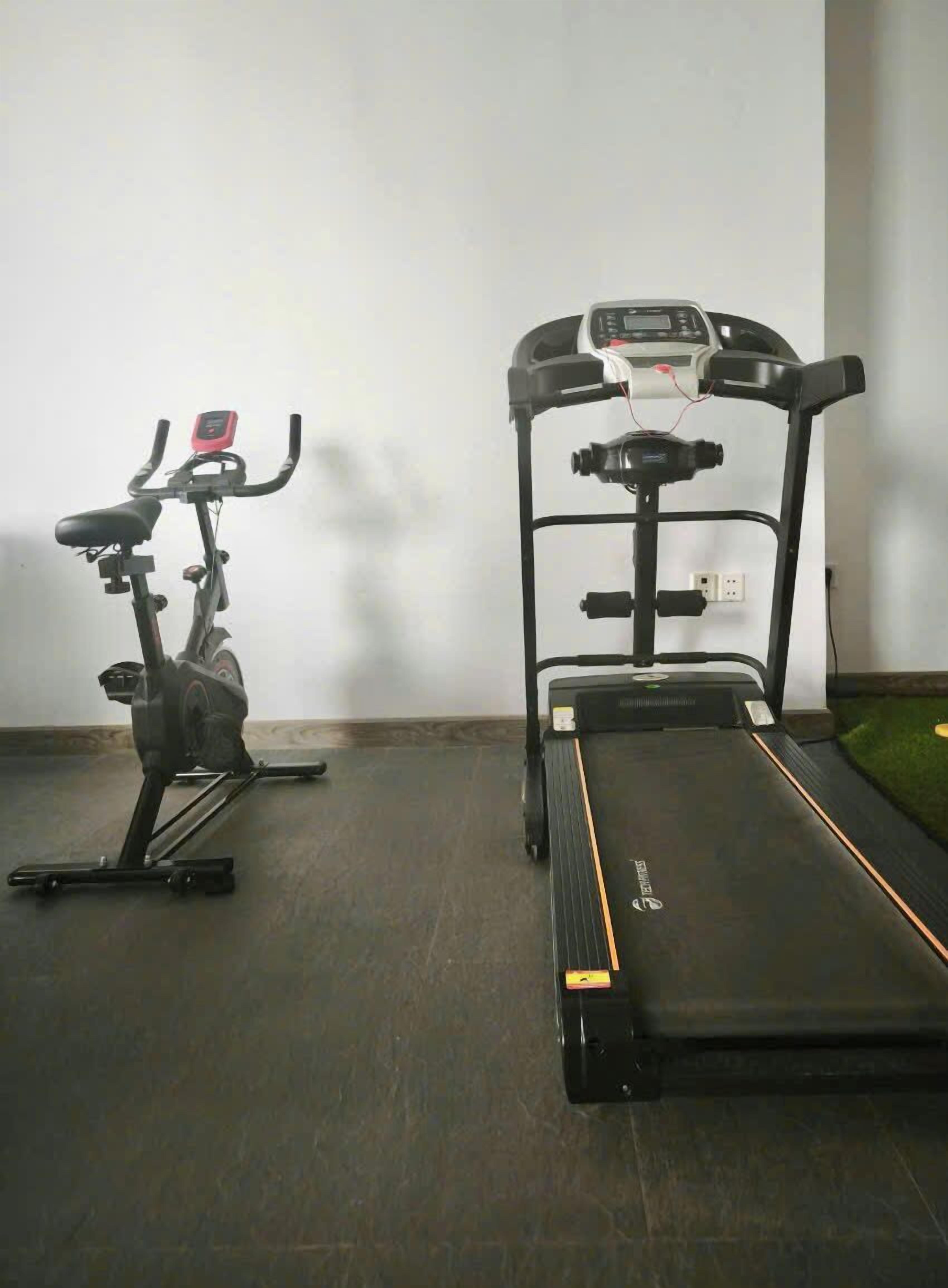 Ein Fitnessraum mit einem Ergometer und einem Laufband.