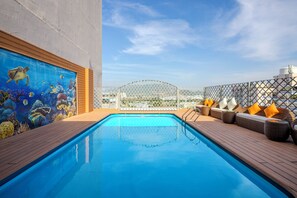 Relax by the pool surrounded by a mural of marine life and enjoy the city skyline views.