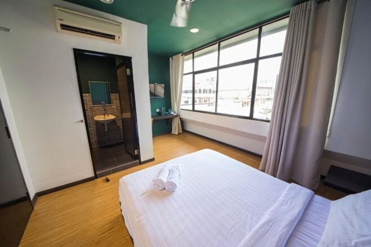 Ein Hotelzimmer mit Bett, Bad, Fenster und Blick auf die Stadt.