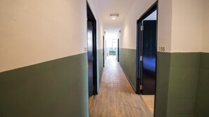 Ein Flur mit den Nummern 101 und 105, Holzboden und einer Deckenleuchte.