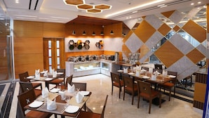 Un comedor moderno con lámparas de techo hexagonales, paneles de madera y una barra tipo buffet.