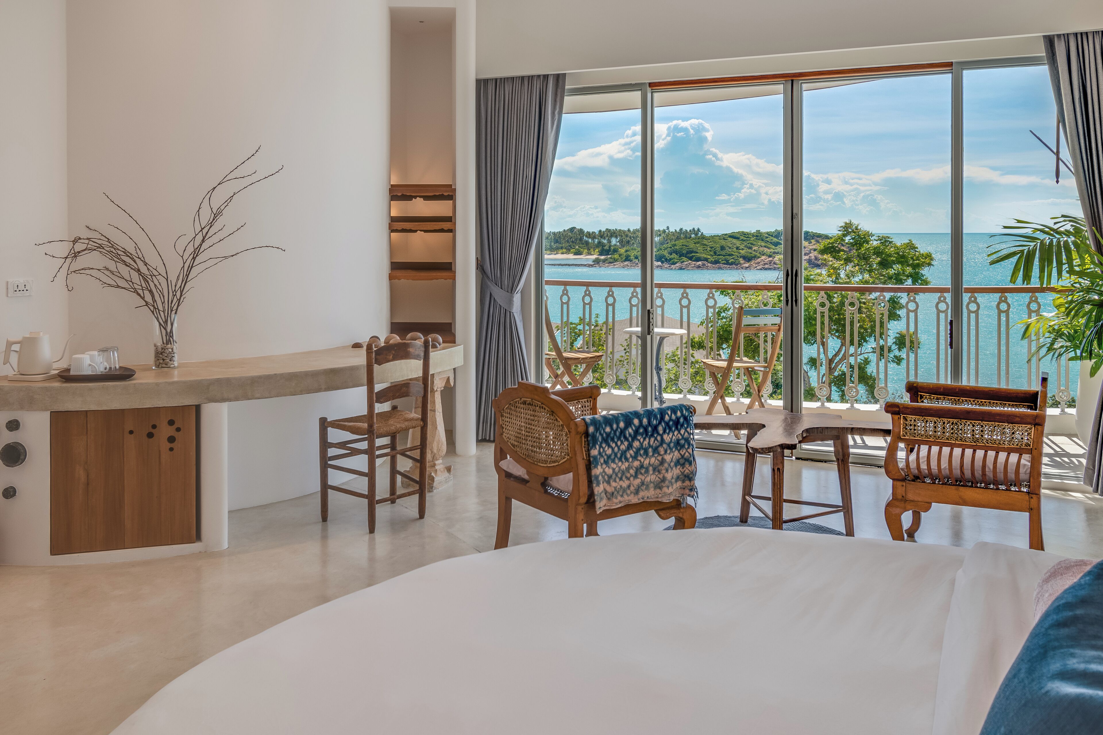 Habitación de hotel con balcón, zona de comedor y vistas al mar.