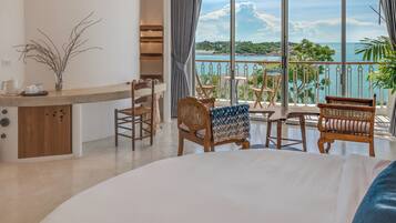 Habitación de hotel con balcón, zona de comedor y vistas al mar.