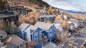 A residential area with a prominent blue house featuring a balcony, a driveway, and a street with cars. - Downtown 3BR Park City Retreat: Walk to Town Lift (Park City)
