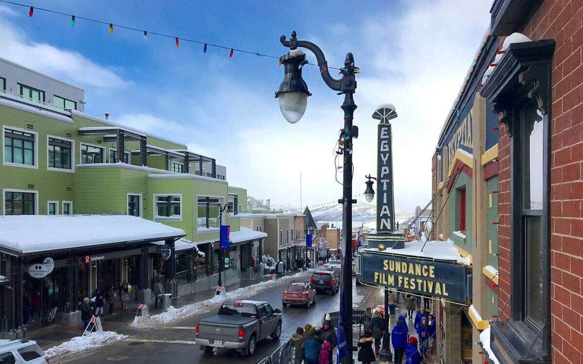 A street with buildings, a film festival sign, and a snow-covered ground.