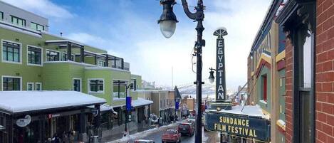 A street with buildings, a film festival sign, and a snow-covered ground.
