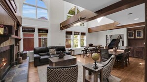 A spacious living area with a fireplace, leather sofa, and a dining table. - Downtown 3BR Park City Retreat: Walk to Town Lift (Park City)
