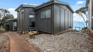 Een modern huis met een grindpad en een klein terras met tuinmeubilair.