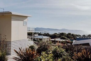 Quartiere residenziale con una casa dotata di balcone, vista sul mare e vegetazione circostante.