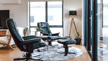 A modern living room with leather chairs, a small table, and a floor lamp.
