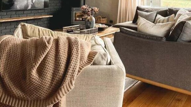 A cozy living room with a fireplace, a sofa, and a television.