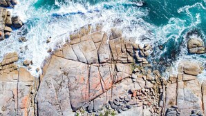 A rocky coastline with waves crashing against the shore.