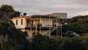 A modern house with a deck, a staircase, and a vehicle parked in front. - Frankie Beach House Bicheno (Glamorgan-Spring Bay)