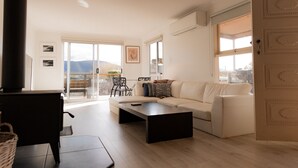 Un salón amplio con un sofá, una mesa de centro y un comedor con sillas.