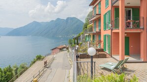 Un bâtiment situé sur la côte, doté de balcons qui offrent une vue sur l’étendue d’eau et les montagnes.