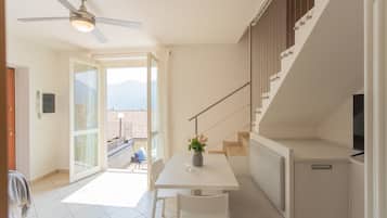 Una cocina moderna con comedor, ventilador de techo y vistas a través de la puerta de cristal.