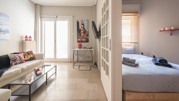 Un apartamento moderno con sala de estar, comedor y habitación.