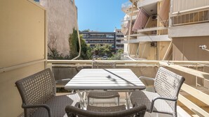 Un balcón con una mesa y sillas, con vistas a una zona residencial con edificios de varios pisos.