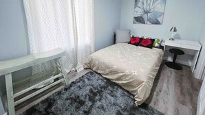 A bedroom with a bed, a desk, a chair, a nightstand, and a window with curtains. - Best garden private single room close LRT&free parking (Calgary)