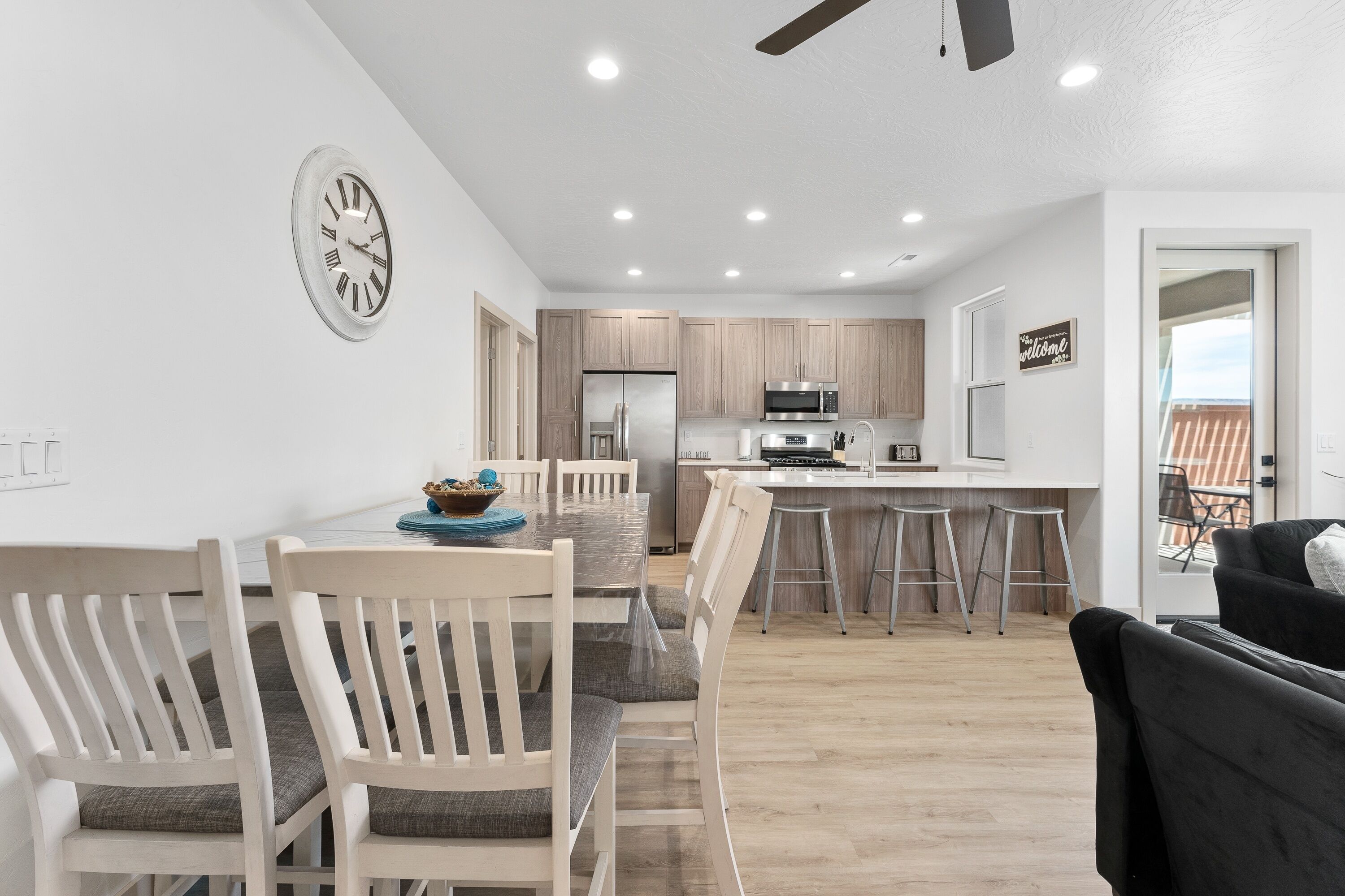 Una cocina moderna con armarios de madera, un refrigerador de acero inoxidable y un microondas.