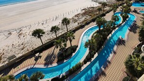 A resort with a beachfront pool area, palm trees, and a sandy beach. - Phoenix West 609 4 Bedroom Condo (Orange Beach)