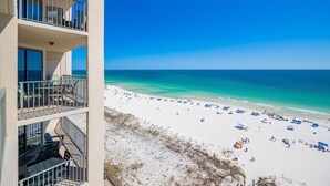 Un hôtel en bord de mer doté de balcons, d’une plage de sable fin et d’une eau cristalline.