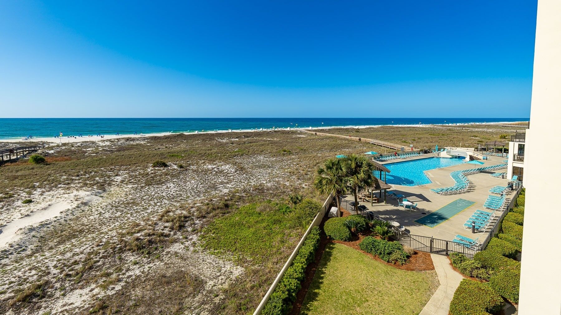 A resort with a pool, beach access, and a view of the ocean.