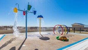 A water play area with multiple water jets and a sunshade structure.
