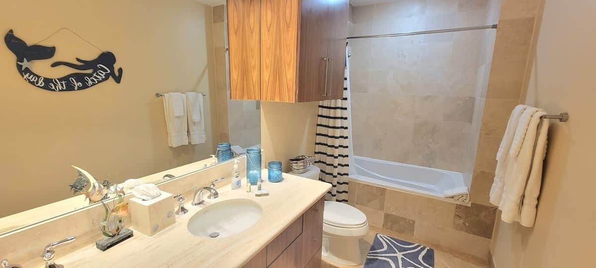 A bathroom with a double sink, a bathtub, and a shower.
