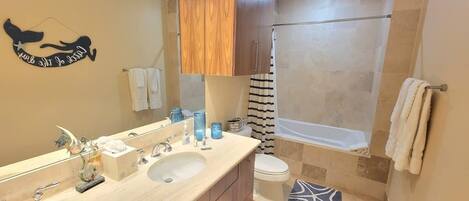 A bathroom with a double sink, a bathtub, and a shower.