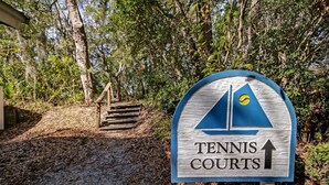A sign for Tennis Courts with a sailboat symbol and an upward arrow. - 5d Amelia Landings 2 Bedroom Condo by RedAwning (Fernandina Beach)