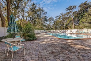 An outdoor swimming pool area with lounge chairs and a table. - 5d Amelia Landings 2 Bedroom Condo by RedAwning (Fernandina Beach)