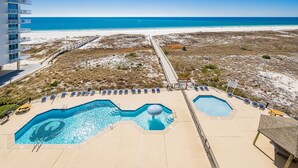 A resort with a pool, beach view, and a boardwalk. - Phoenix Viii 8604 3 Bedroom Condo (Orange Beach)