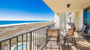 A balcony with a view of the beach and ocean, furnished with chairs and a table. - Phoenix Viii 8604 3 Bedroom Condo (Orange Beach)