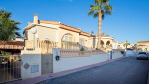 A residential building with a gated entrance, a palm tree, and a clear blue sky. - CH Casa Clementina Rojales (Rojales)