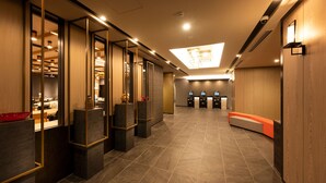 Un moderno vestíbulo de hotel con mostrador de recepción, zona de estar y vista al mostrador.