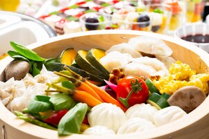 Un saladier en bois rempli de divers légumes frais et de fromage mozzarella.