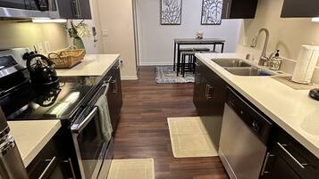Una cocina moderna con armarios oscuros, electrodomésticos de acero inoxidable y una isla central.