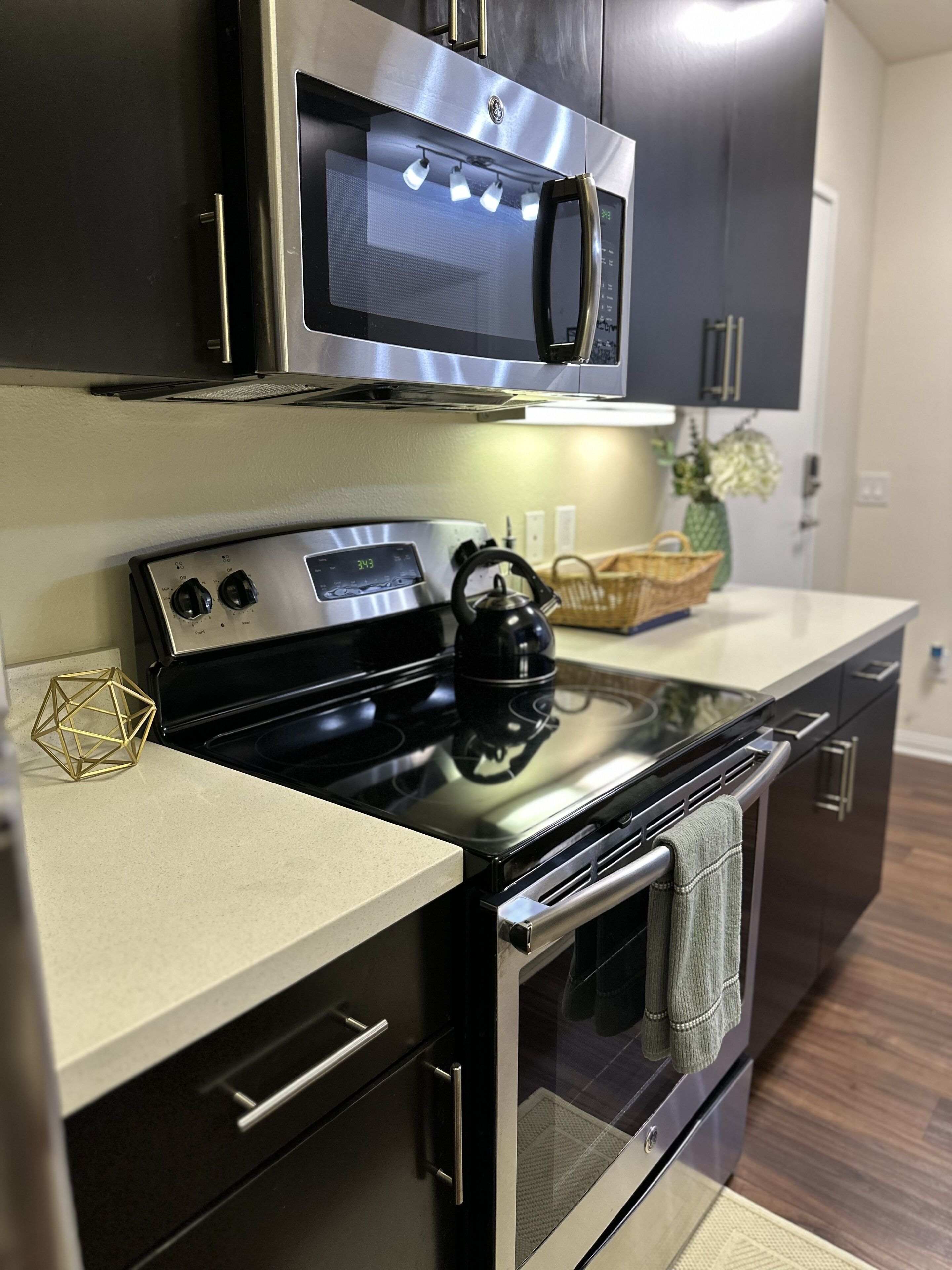 A modern kitchen with stainless steel appliances, including a microwave, oven, and stove.