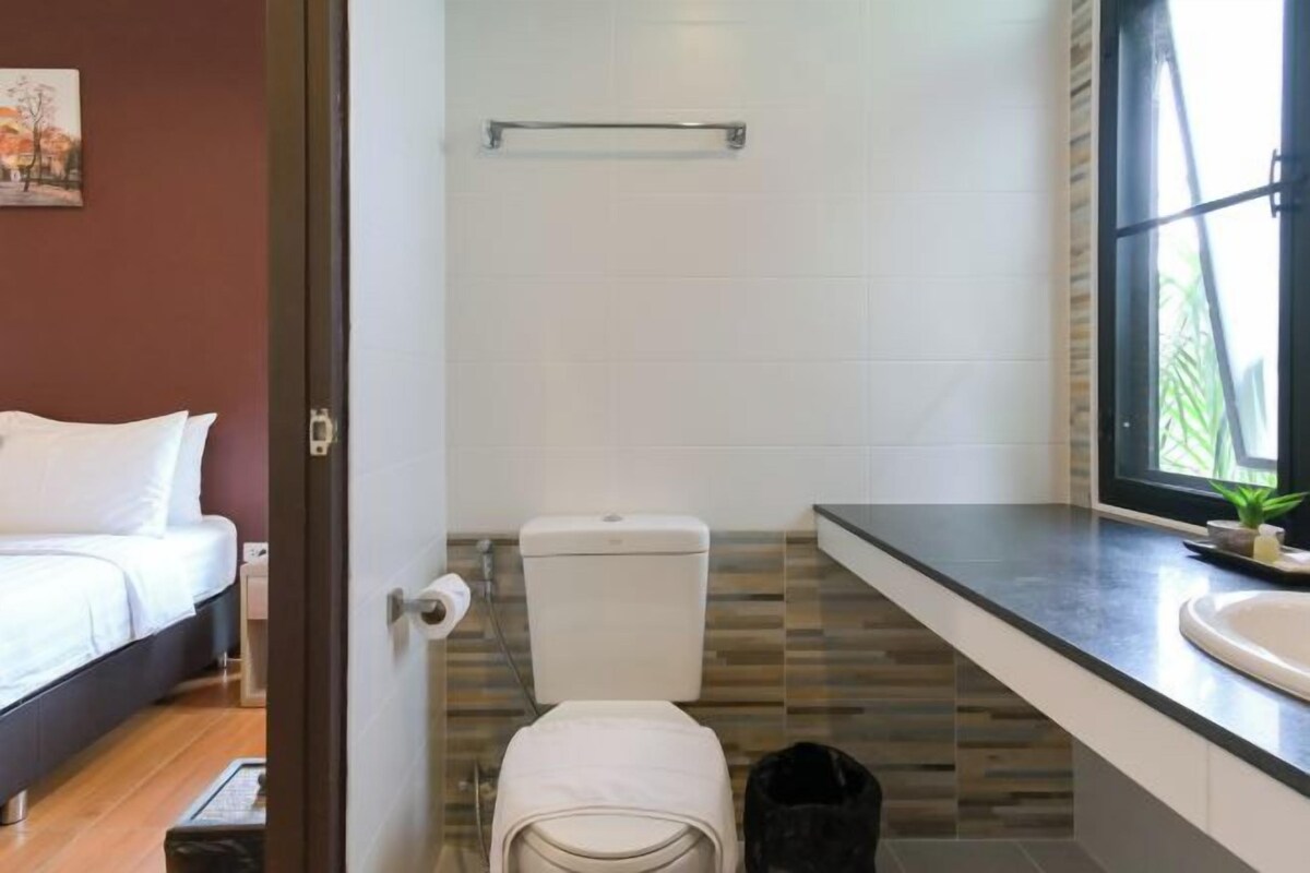 Ein modernes Badezimmer mit Toilette, Waschbecken und einem Fenster für natürliches Licht.