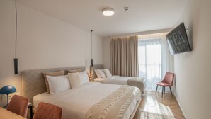 A modern hotel room with a large bed, a desk, and a chair. - IRA-HPA Hotel (Kalamata)