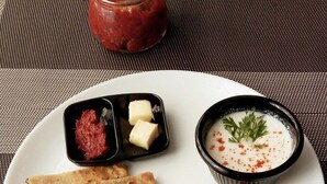 A plate with flatbreads, a jar of chutney, and a bowl of raita. - HOTEL PARK ROYAL  (Panchkula)